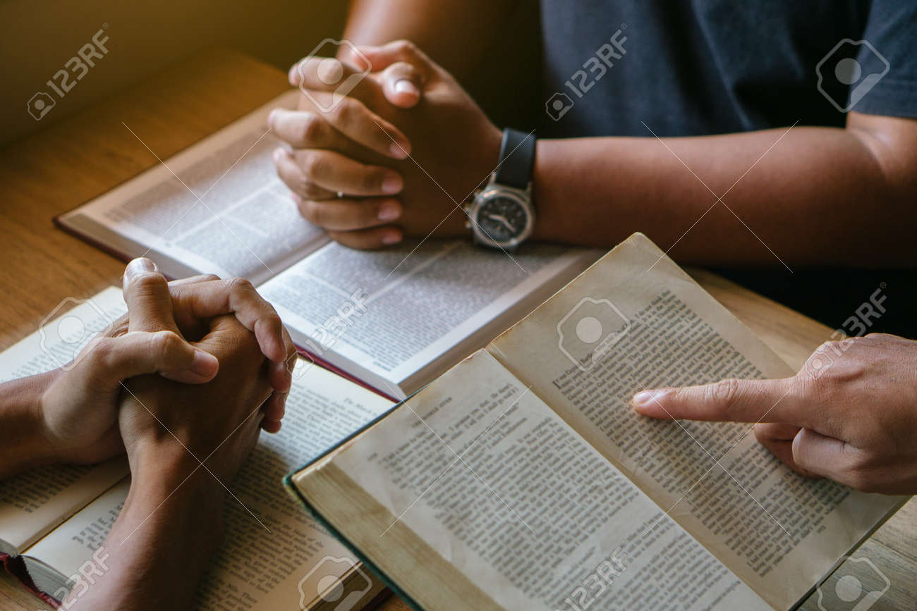 175373608-group-of-christian-people-reading-and-study-bible-in-home-and-pray-together-people-hands-praying
